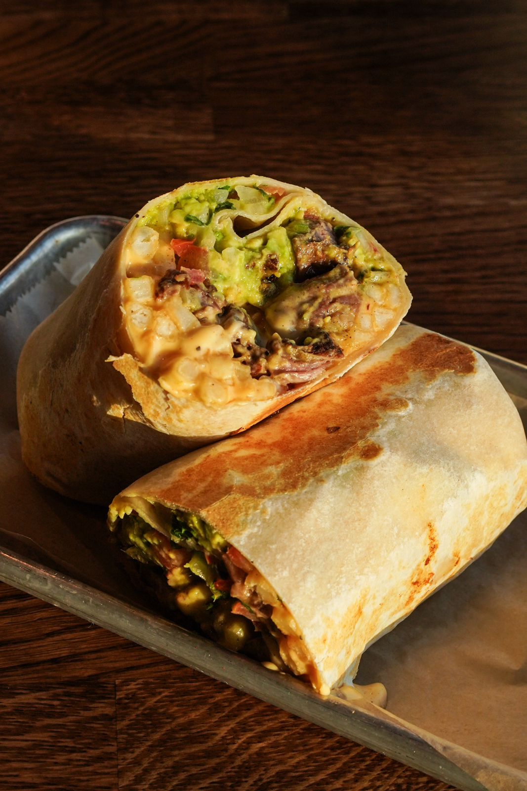 Loaded burrito cut in half at La Lola Taco